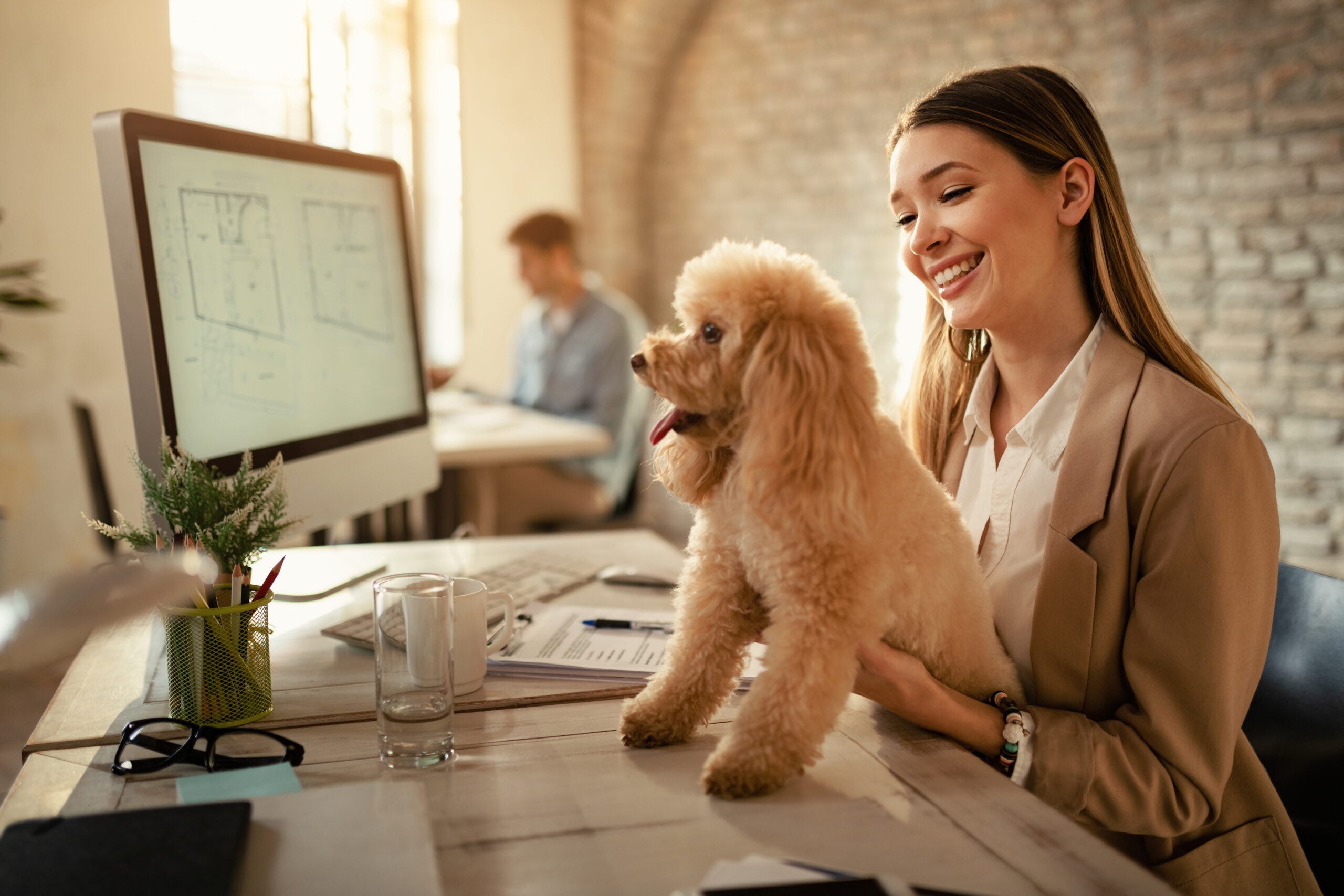 happy businesswoman enjoying with her dog while working in the o
